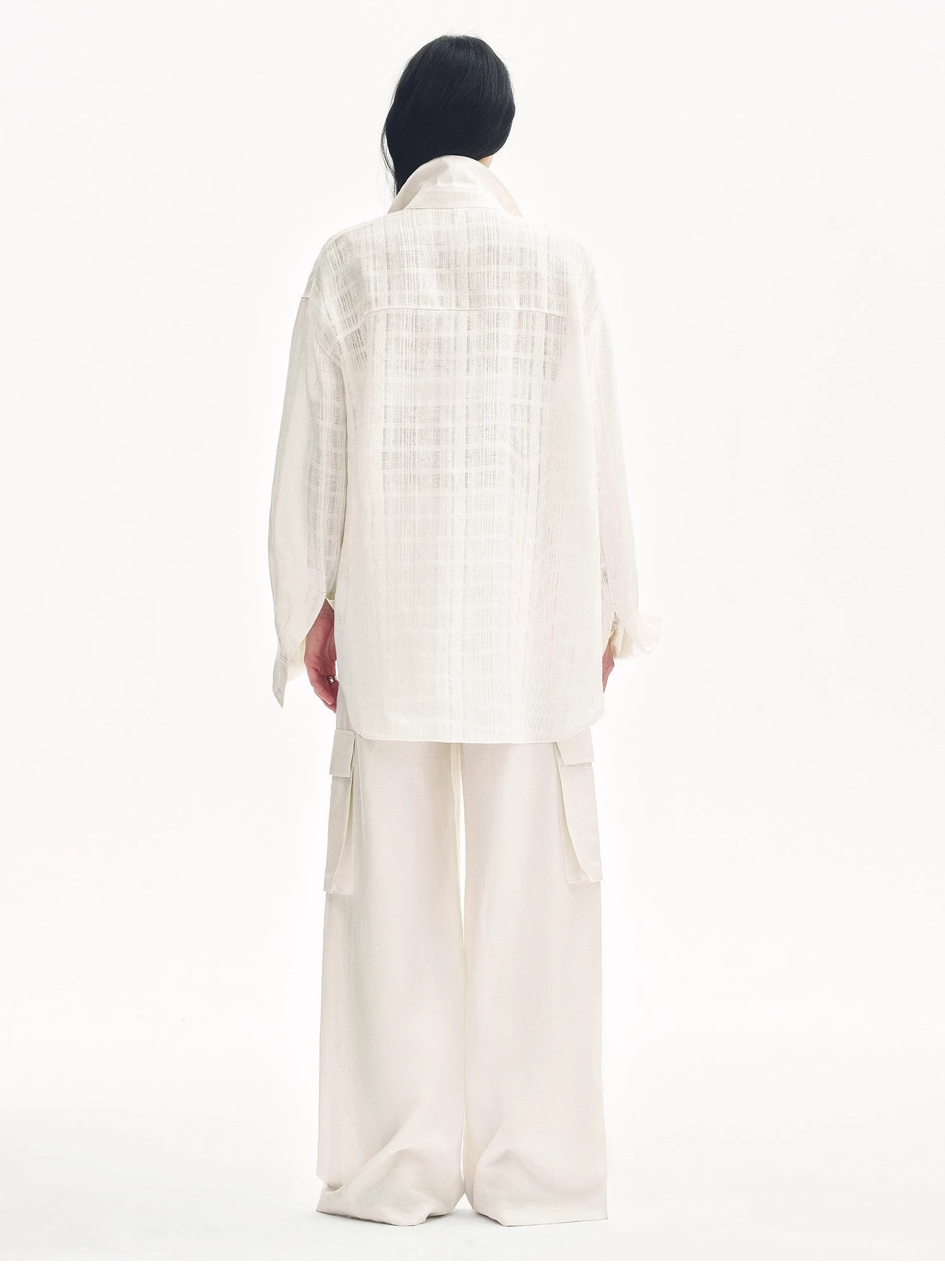 Person wearing a white outfit with a headscarf on a white background