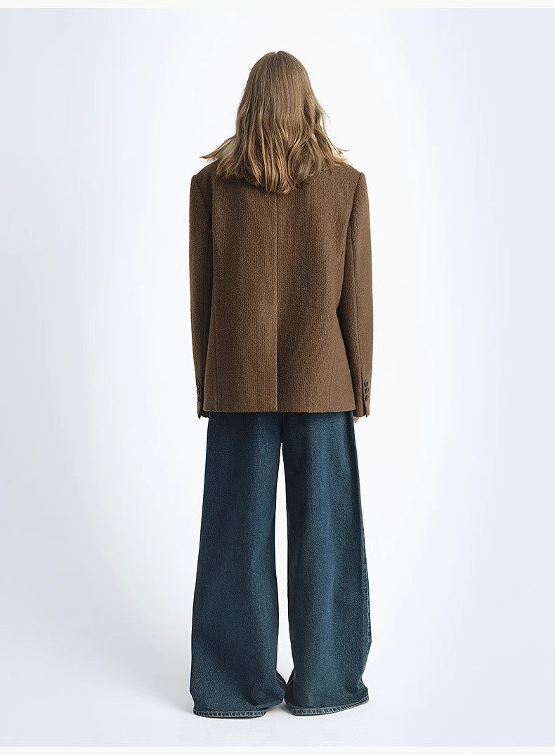 Person wearing a brown coat and blue jeans from behind on a white background