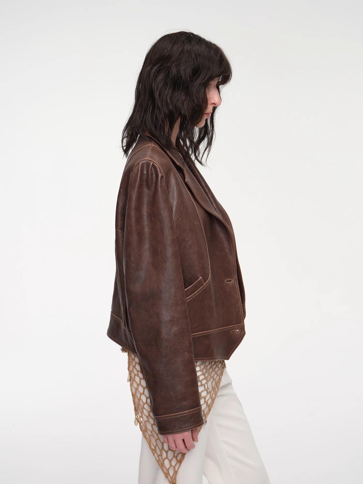 Person wearing a brown leather jacket on a white background