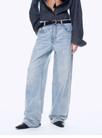 Person wearing light blue jeans and a dark shirt on a white background