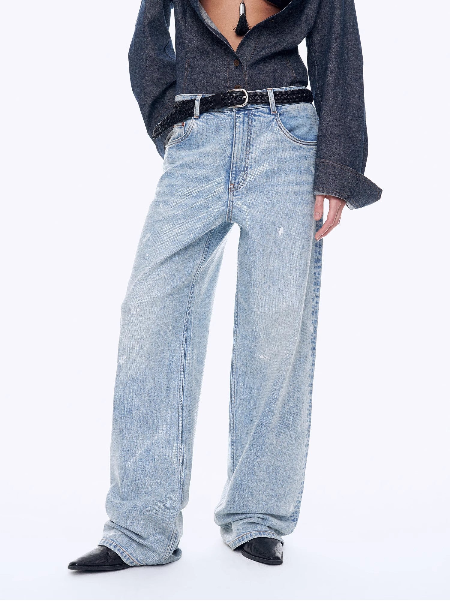 Person wearing light blue jeans and a dark shirt on a white background