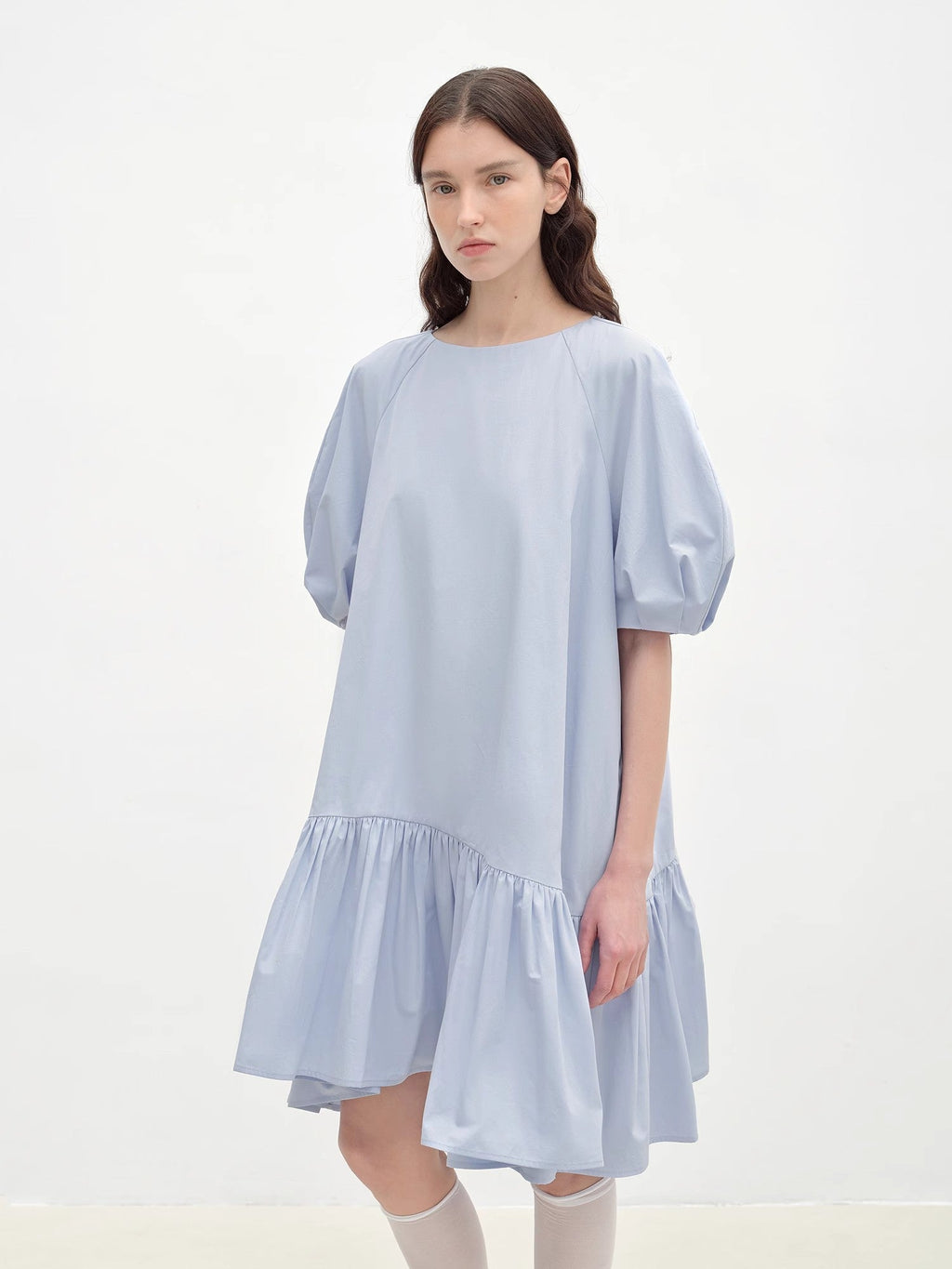 Woman wearing a light blue dress on a white background