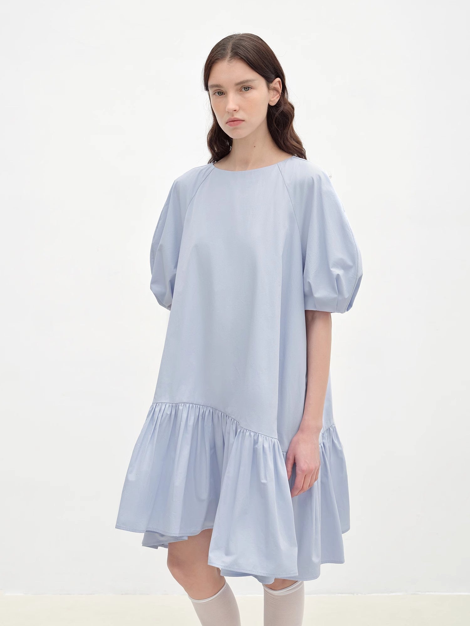 Woman wearing a light blue dress on a white background