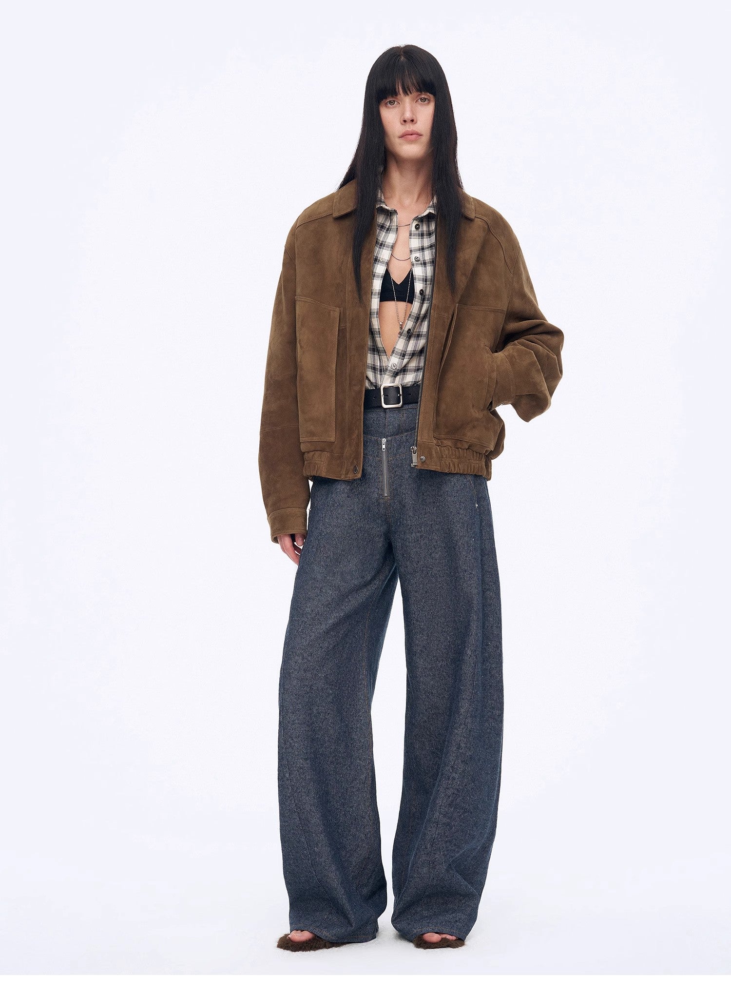 Person wearing a brown jacket and blue jeans on a white background