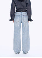 Person wearing light blue jeans and a dark shirt on a white background