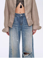 Person wearing a beige shirt and blue jeans on a white background