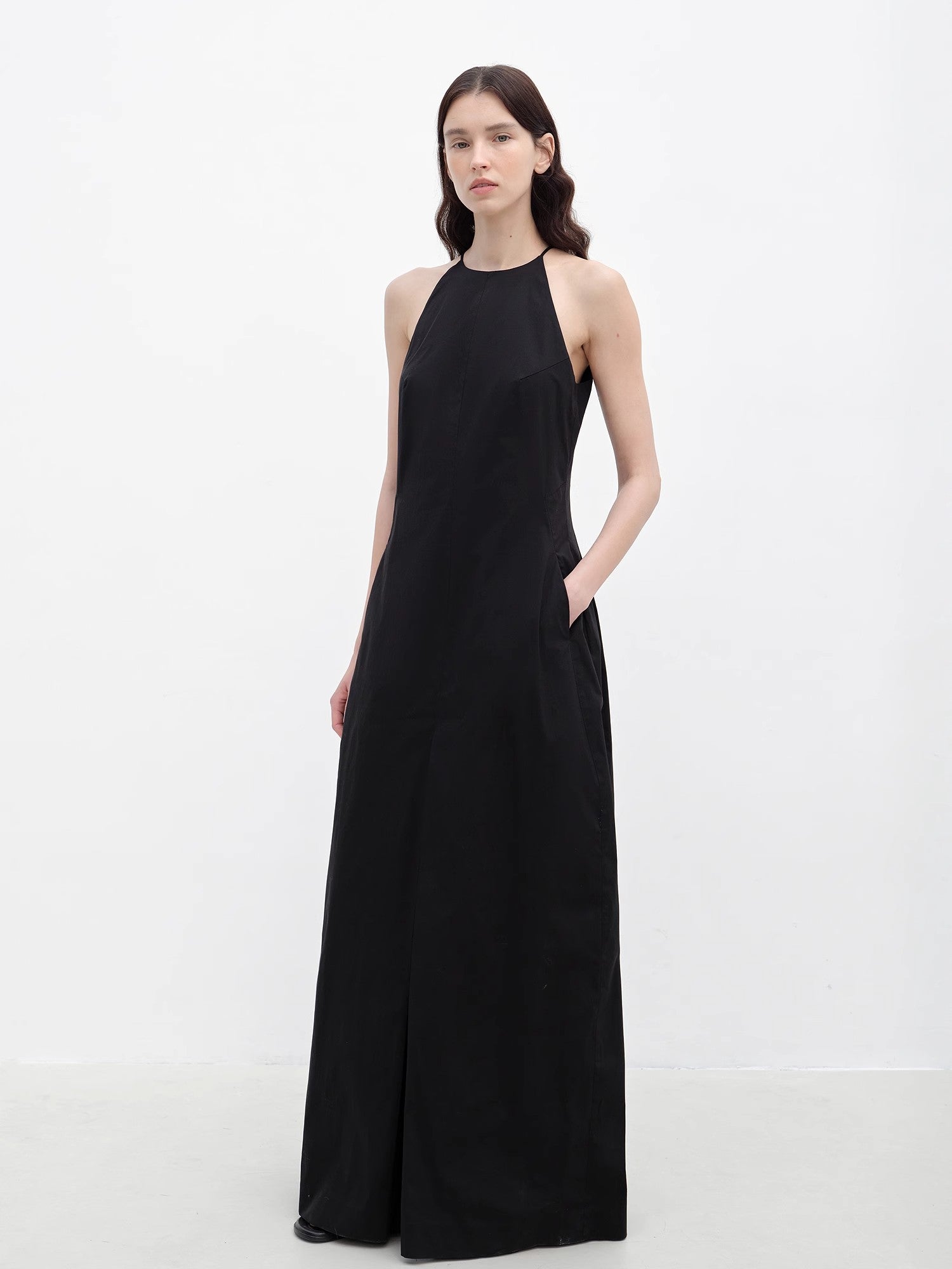 Woman wearing a black sleeveless dress on a white background