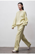 Person wearing a light green outfit against a plain background