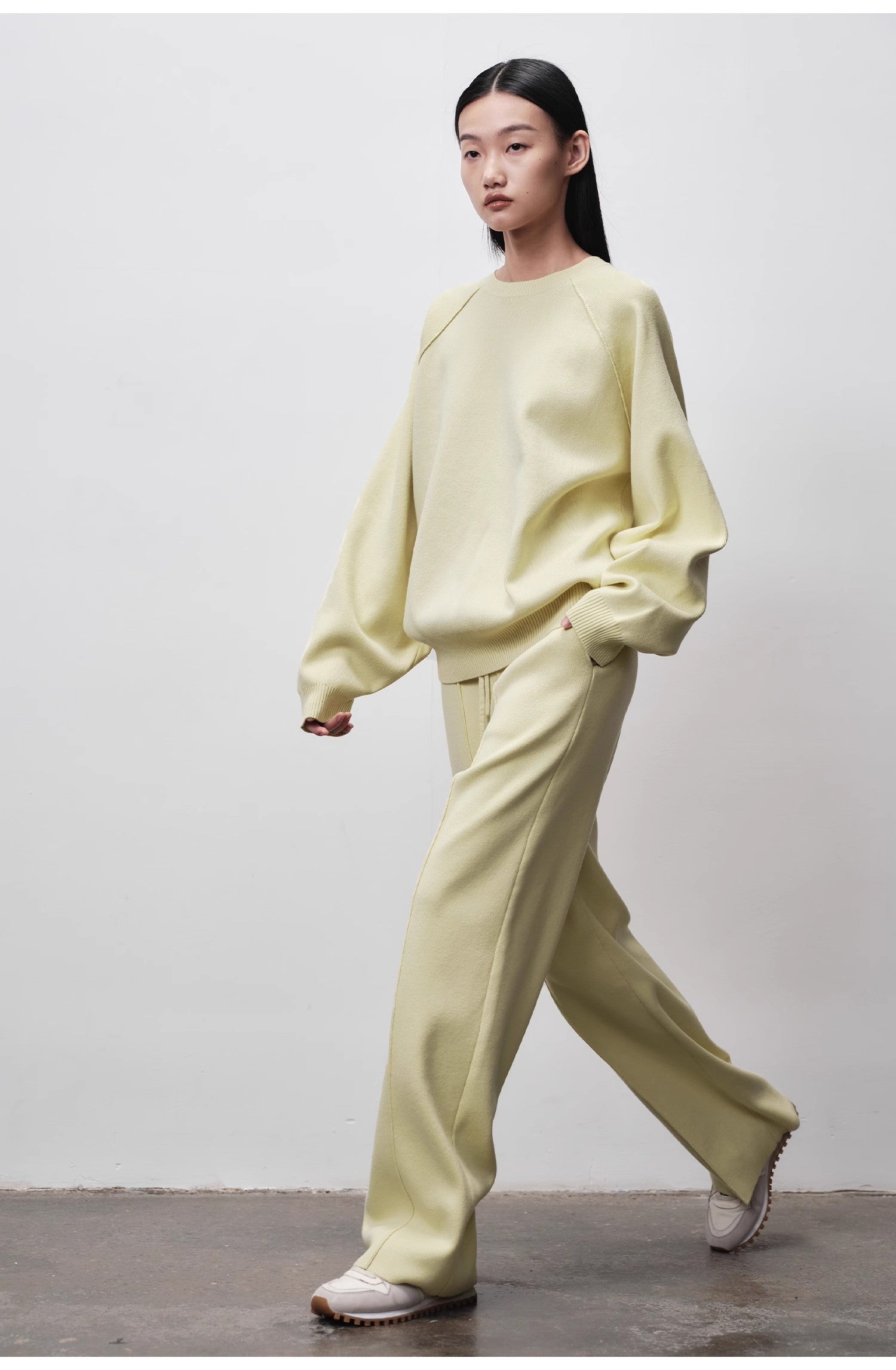 Person wearing a light green outfit against a plain background