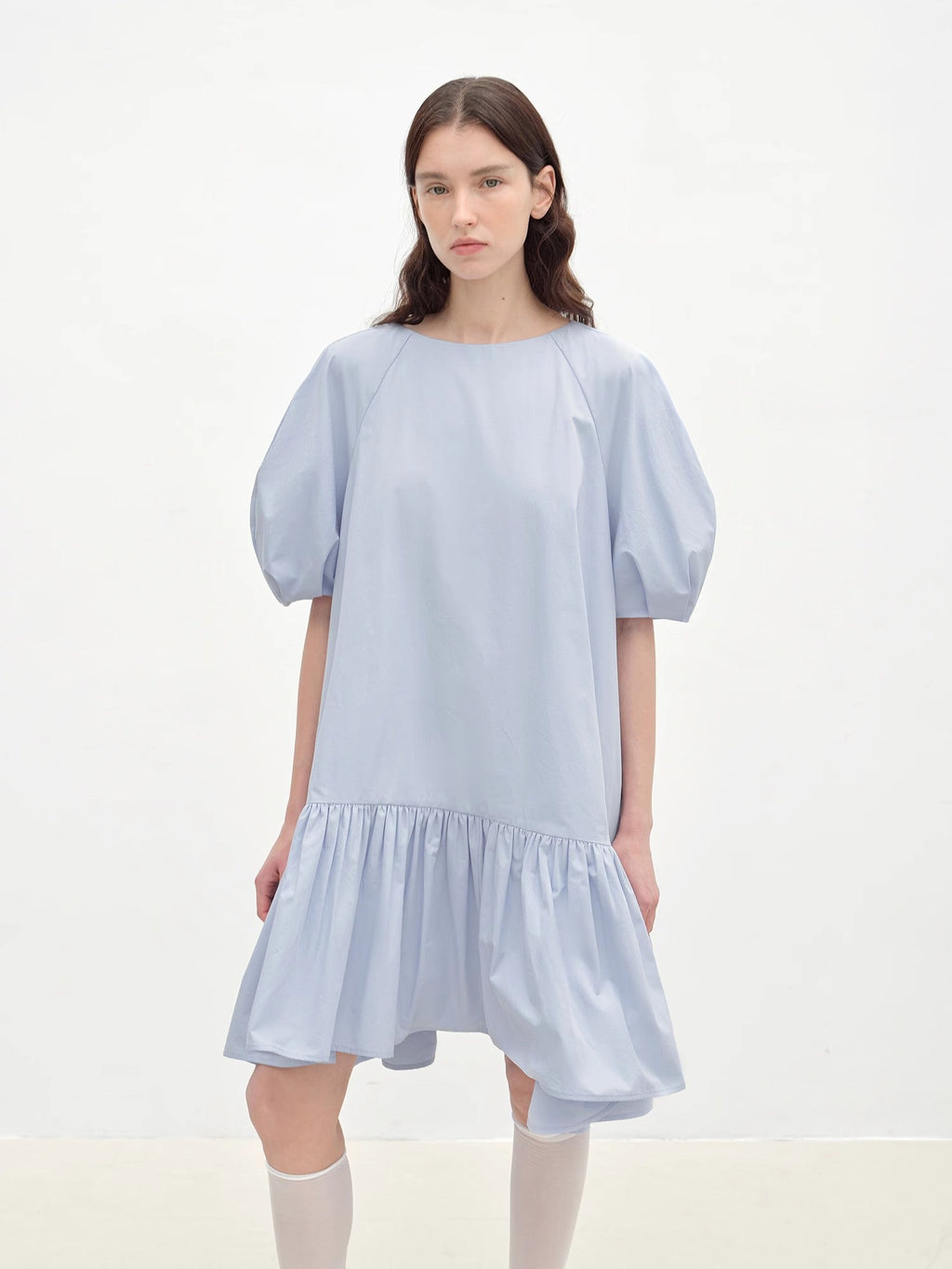 Woman wearing a light blue dress on a white background