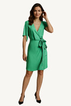 Woman wearing a green dress against a dark background