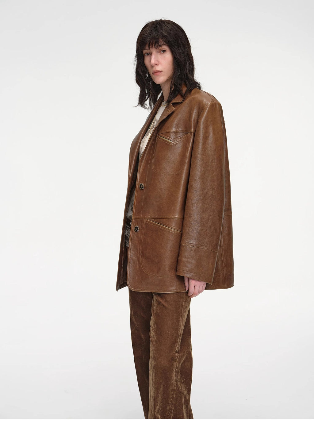 Person wearing a brown leather jacket and pants on a white background