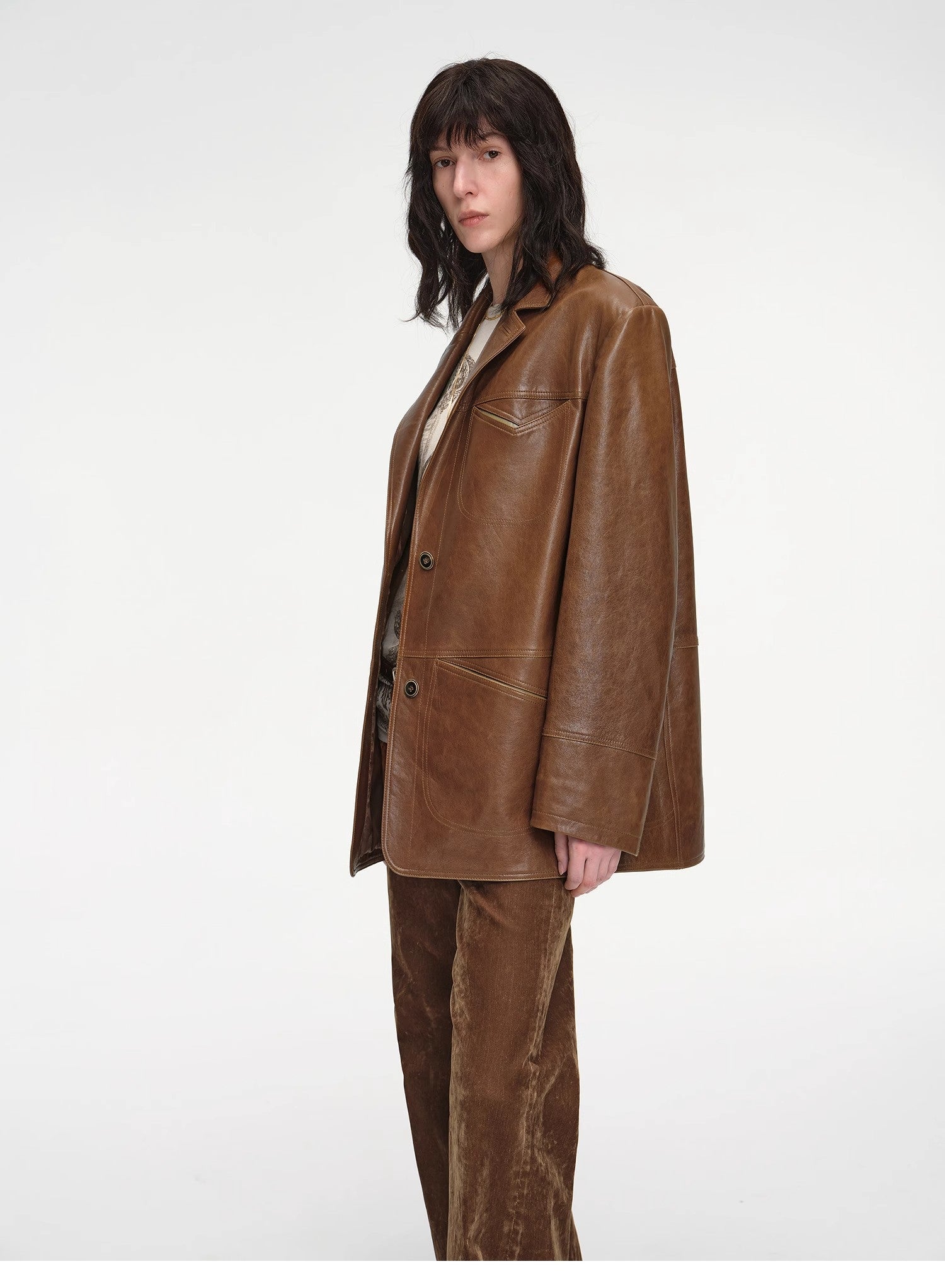 Person wearing a brown leather jacket and pants on a white background