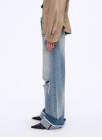 Person wearing a beige jacket and blue jeans on a white background