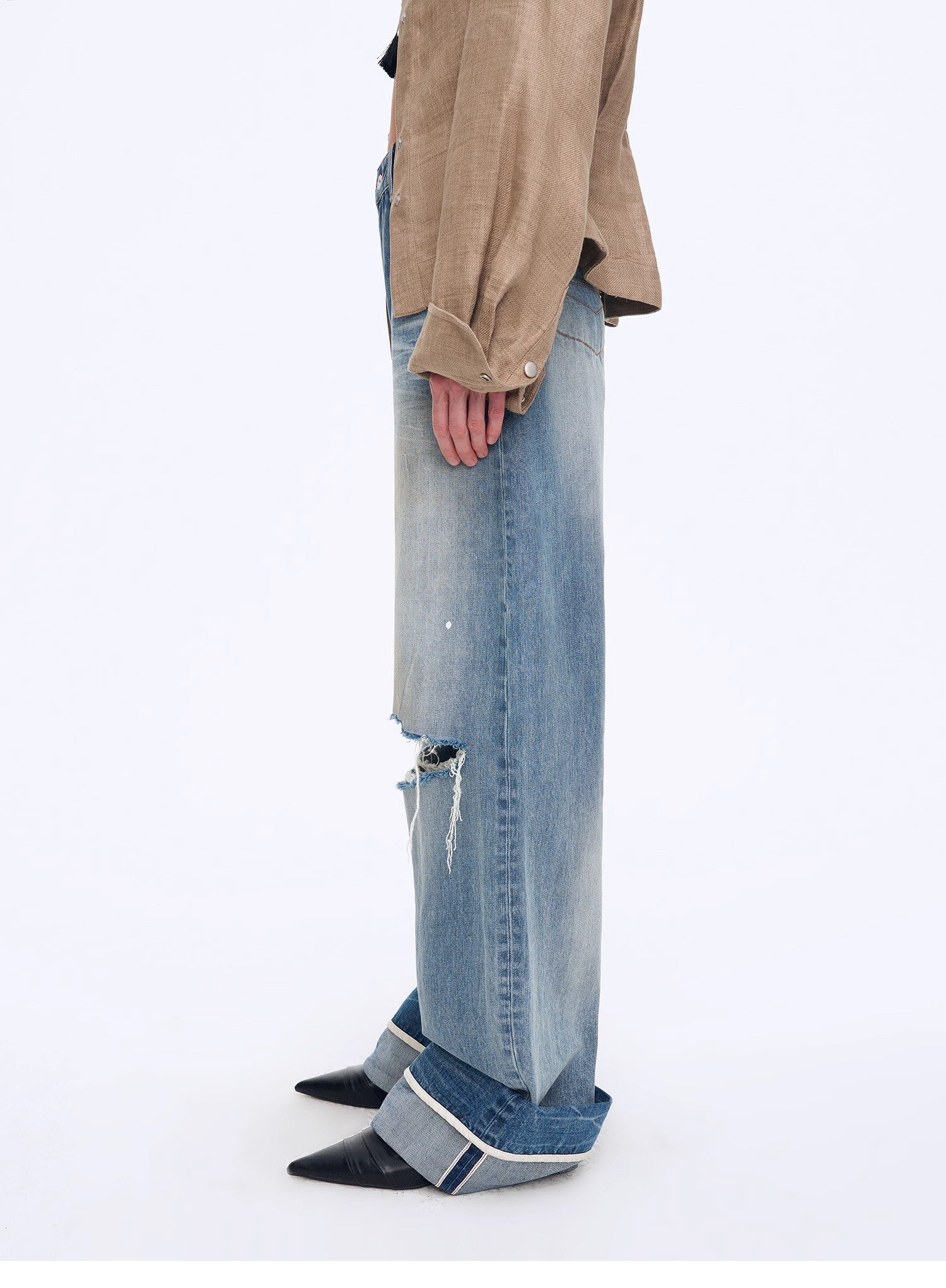 Person wearing a beige jacket and blue jeans on a white background