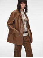 Person wearing a brown leather jacket and pants on a white background