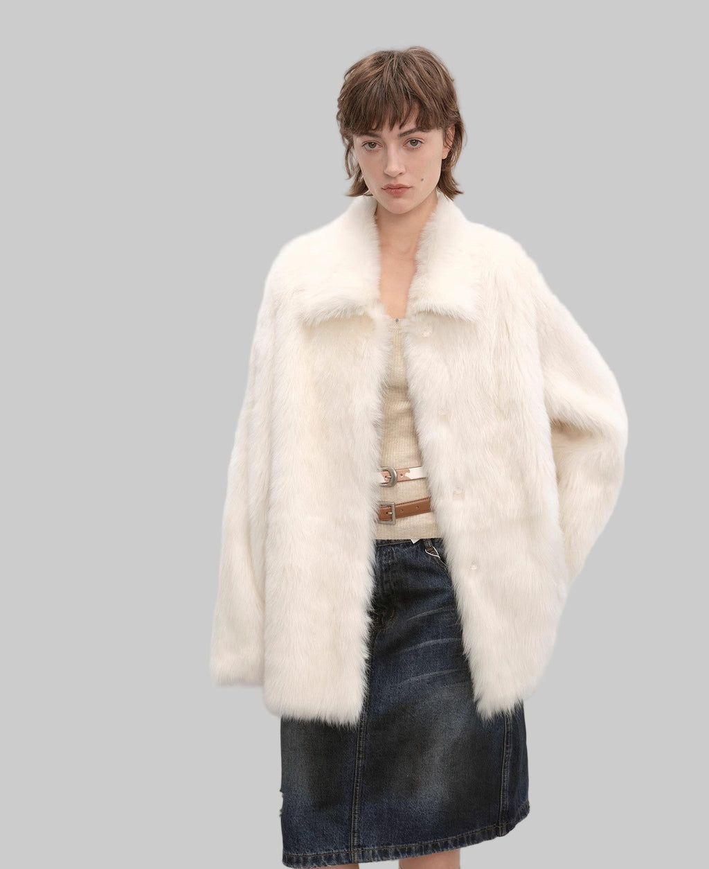 Woman wearing a white fur coat with a plain background