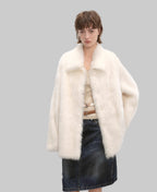 Woman wearing a white fur coat with a plain background