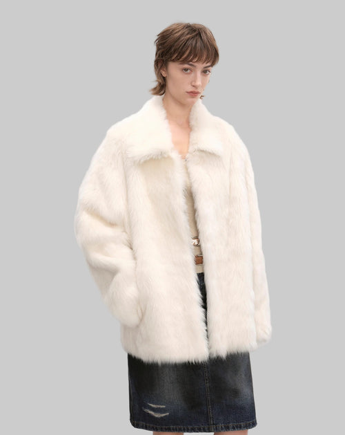 Person wearing a white fur coat and black skirt against a white background