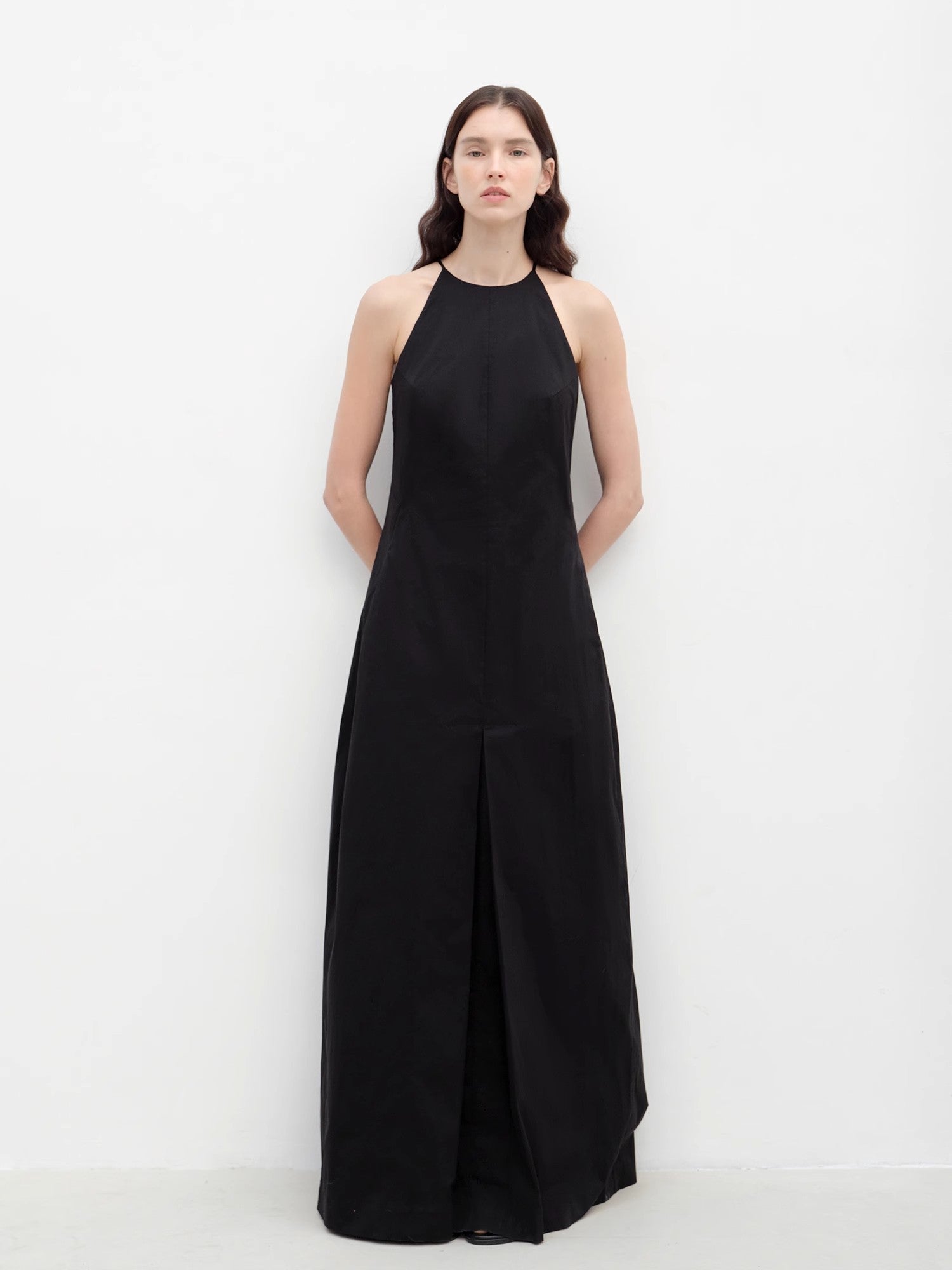 Woman wearing a black halter neck dress on a white background