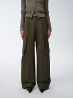Person wearing olive green cargo pants and a matching cardigan on a white background