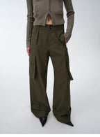 Person wearing a brown knitted cardigan and wide-leg cargo pants on a white background