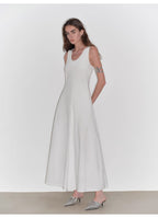 Woman wearing a white dress with a plain background