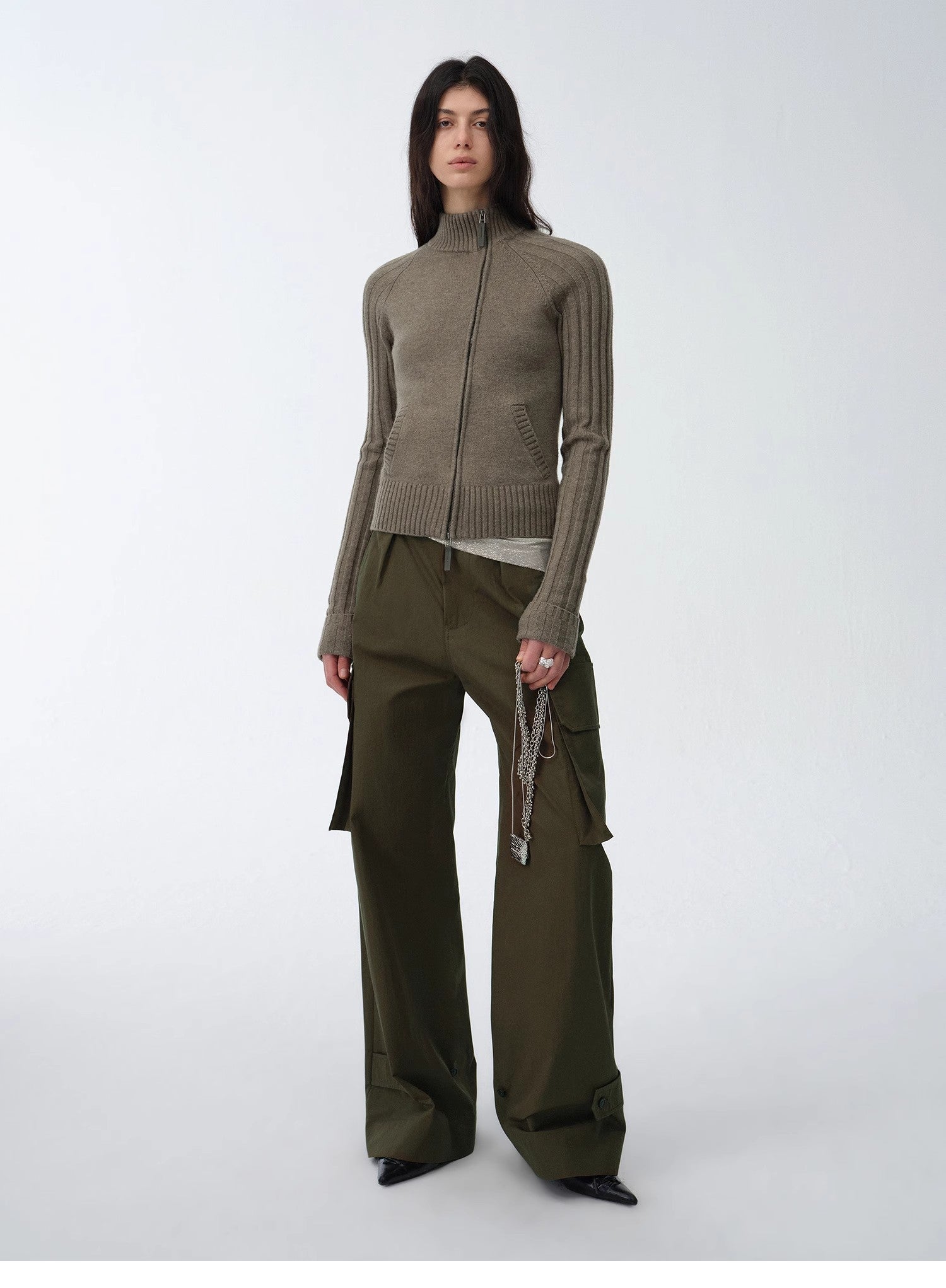 Woman wearing a green outfit with a jacket and pants on a white background