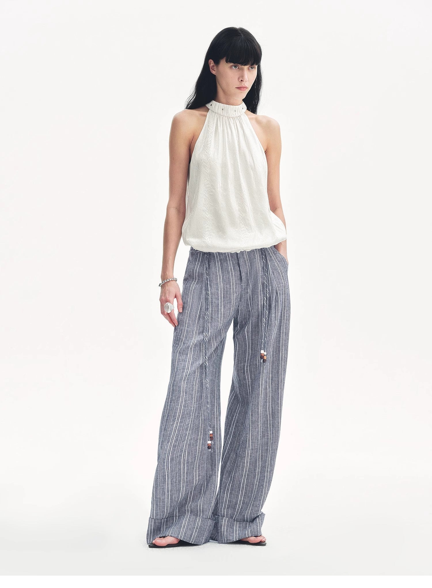 Woman wearing a white top and striped pants on a white background