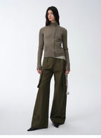 Person wearing a green knit cardigan and wide-leg pants on a white background