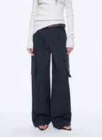 Person wearing black cargo pants and a white top on a white background