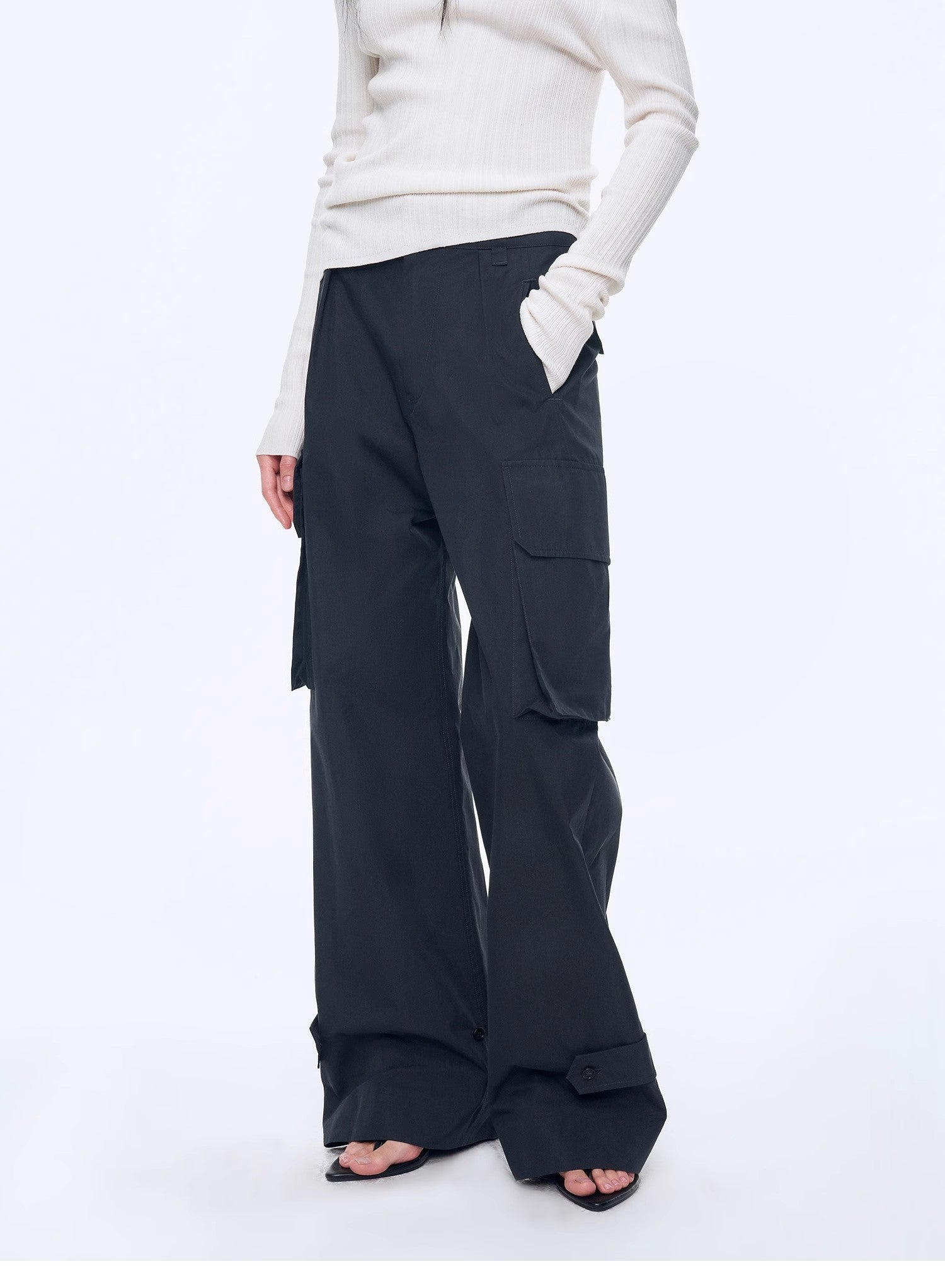 Person wearing black cargo pants on a white background