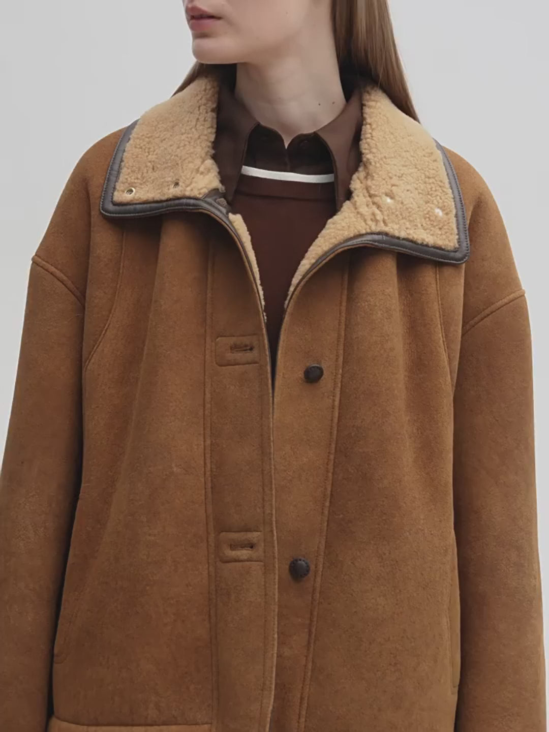 Brown coat with a textured collar on a plain background