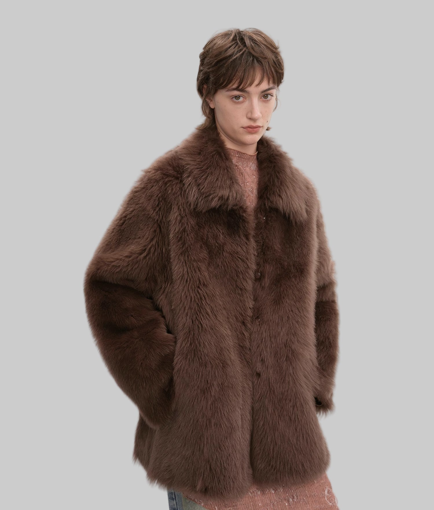 Person wearing a brown fur coat on a white background