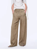 Person wearing beige wide-leg pants on a white background