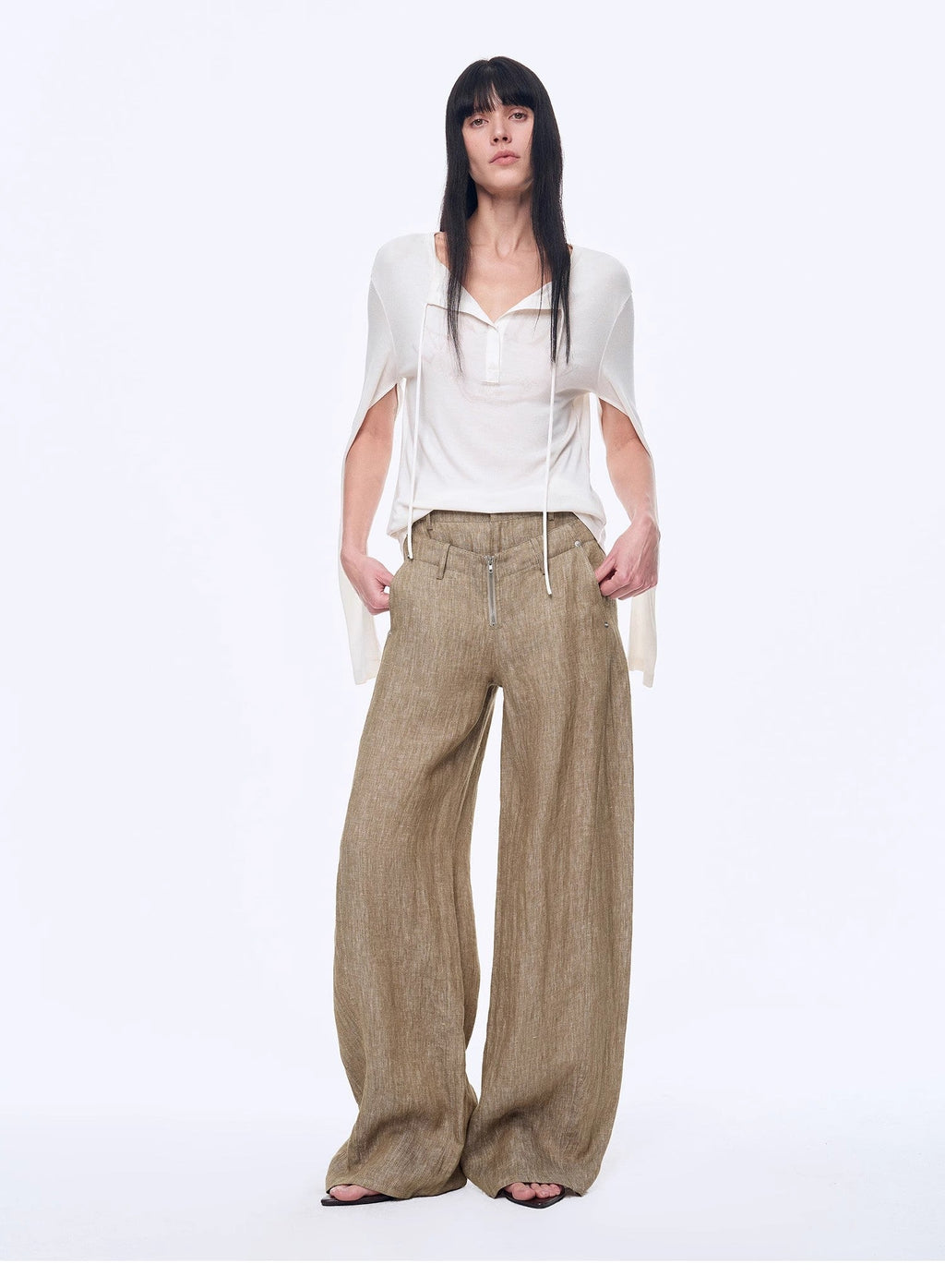 Woman wearing a white top and beige wide-leg pants on a white background