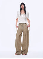 Woman wearing a white top and beige wide-leg pants on a white background