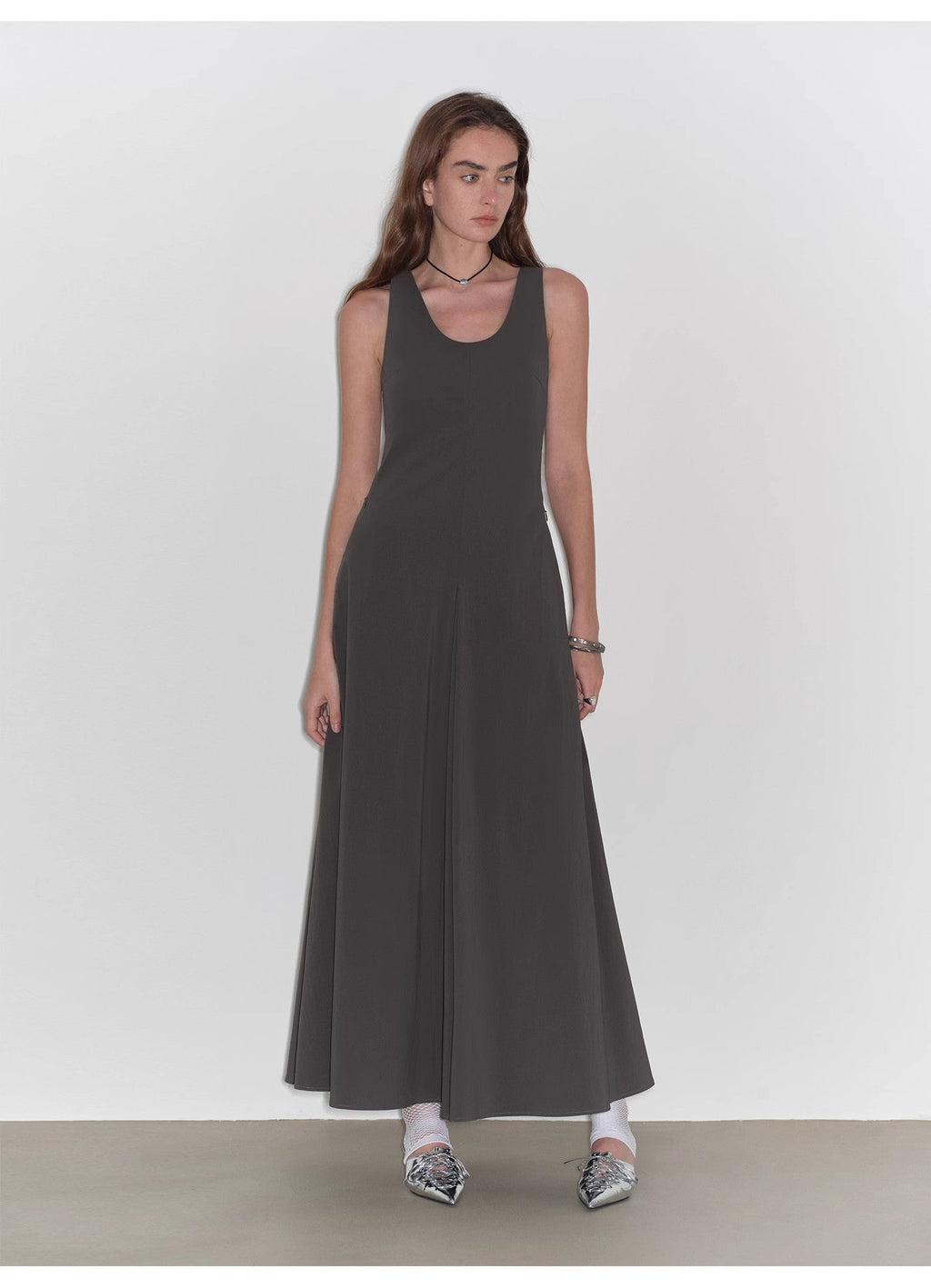 Woman wearing a black sleeveless dress against a white background