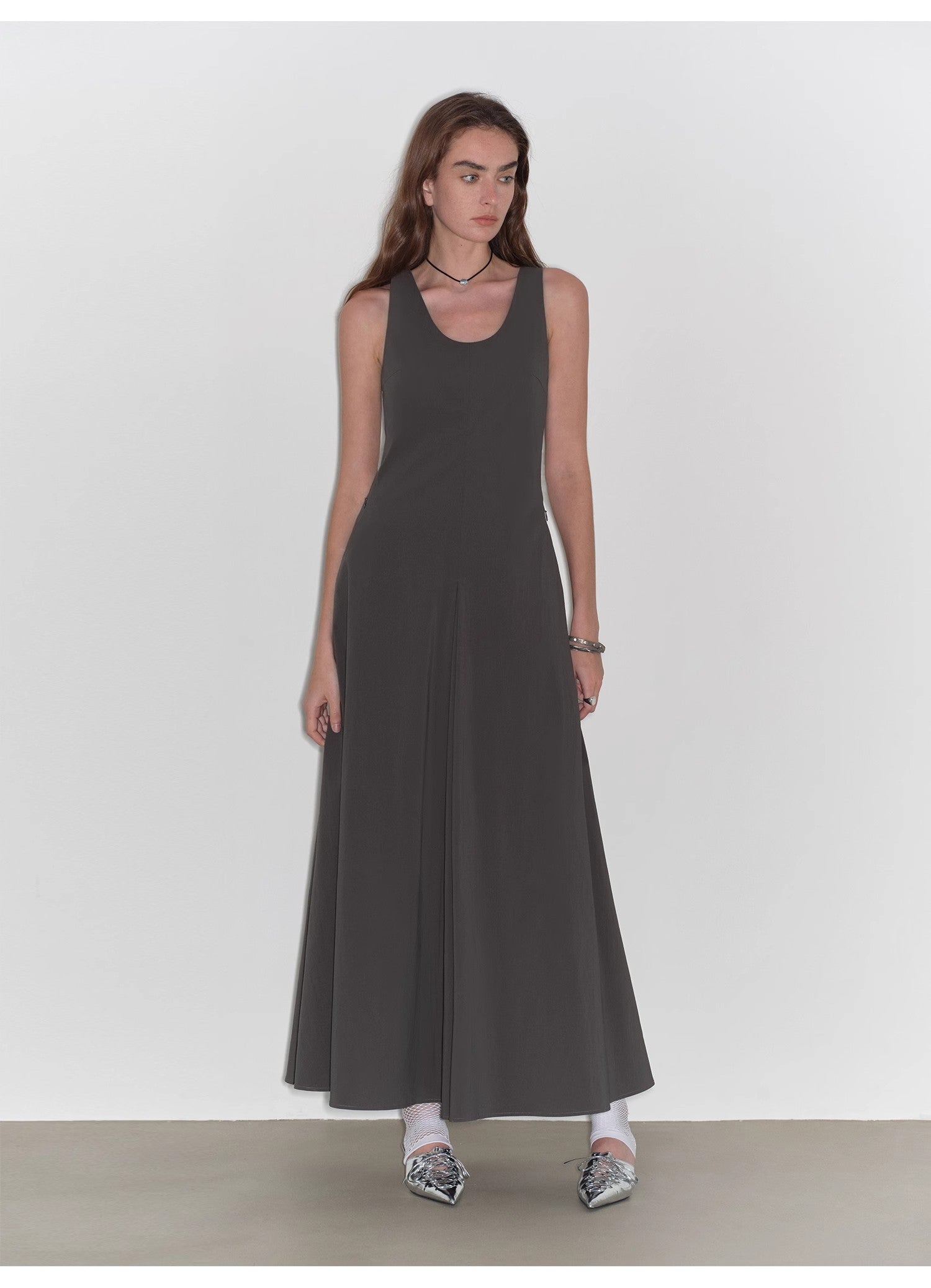 Woman wearing a black sleeveless dress against a white background
