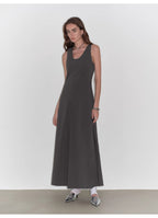 Woman wearing a long dark gray dress against a white background