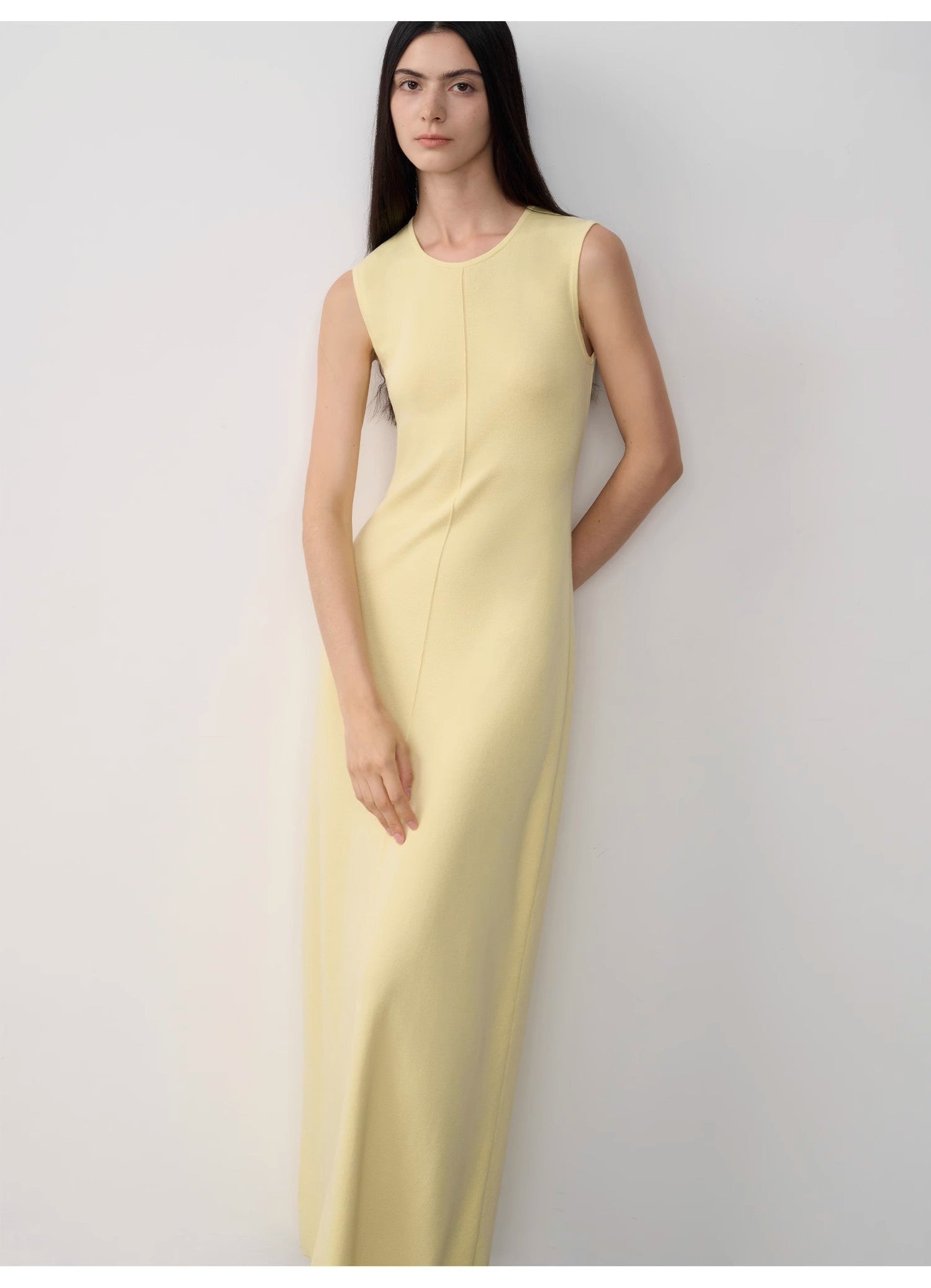 Woman wearing a light yellow dress against a white background