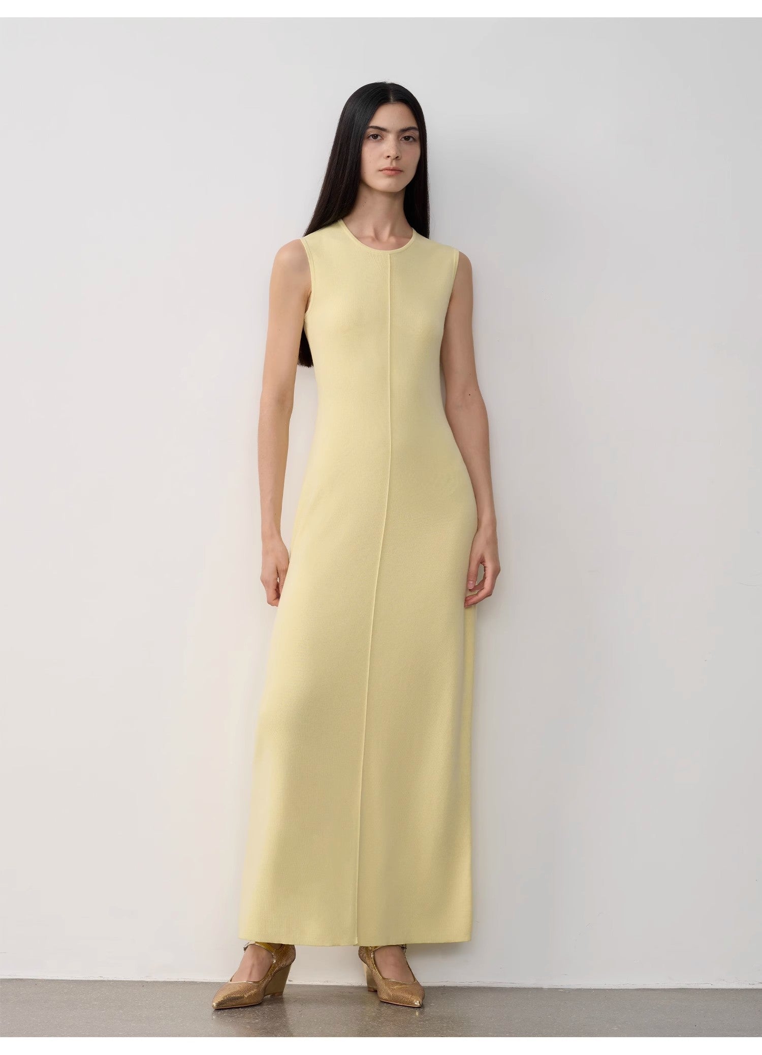 Woman wearing a light yellow dress against a white background