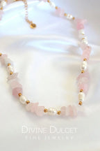 Necklace with pink and white beads on a white background, featuring 'Divine Dulcet Fine Jewelry'.