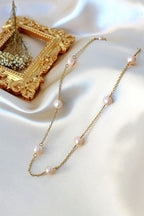 Gold necklace with pearls on a white fabric background