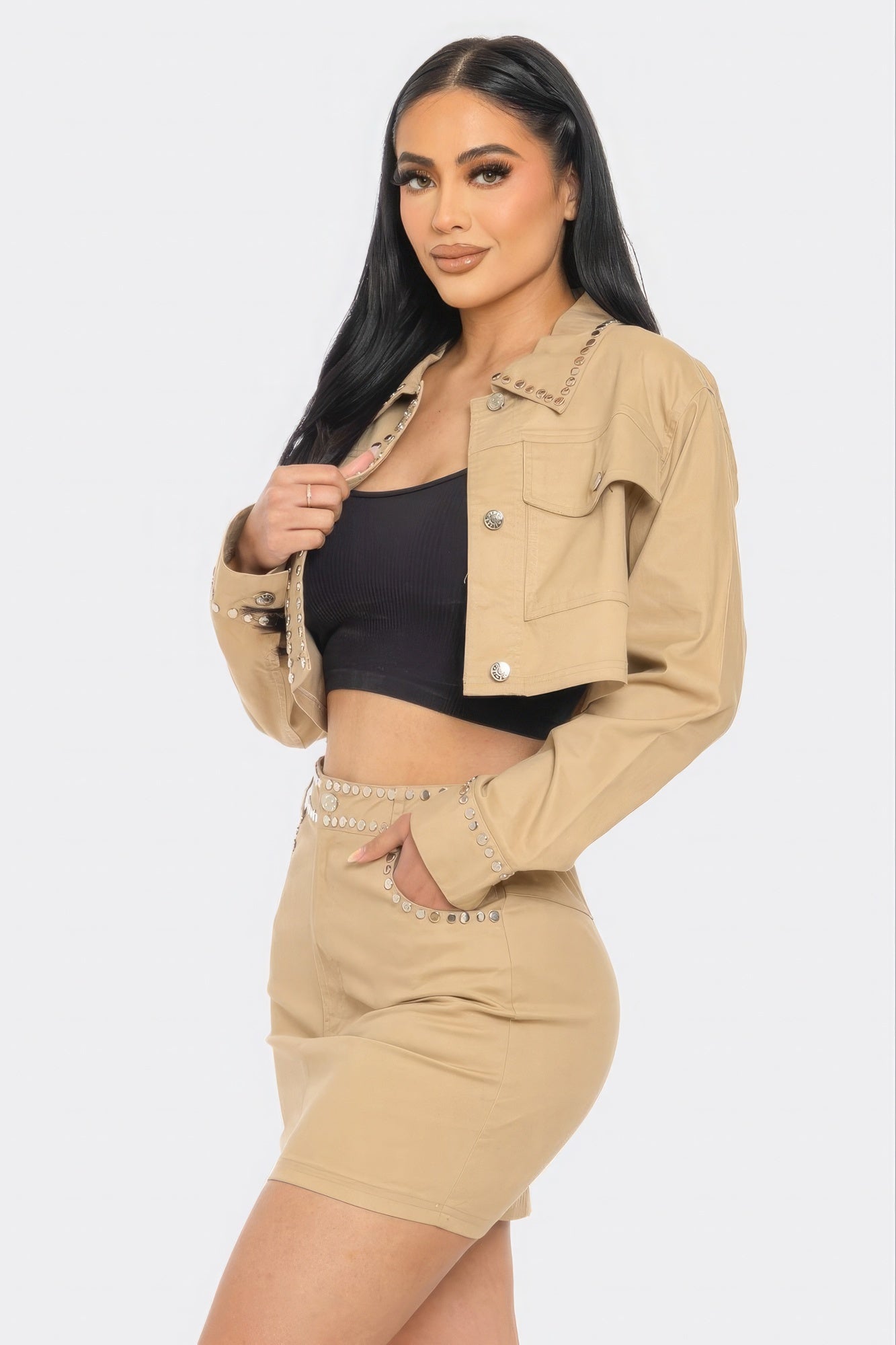 Woman wearing a beige jacket and shorts set on a white background