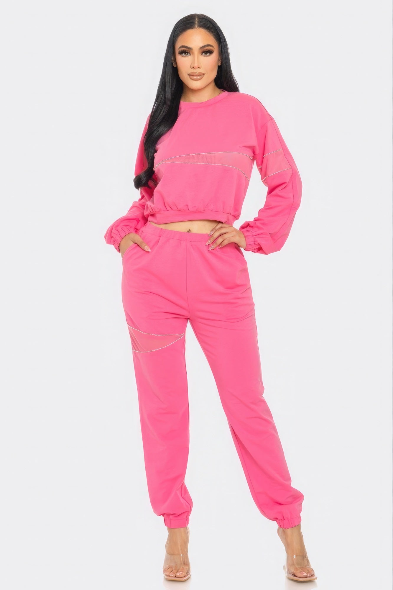 Woman wearing a bright pink matching set on a white background