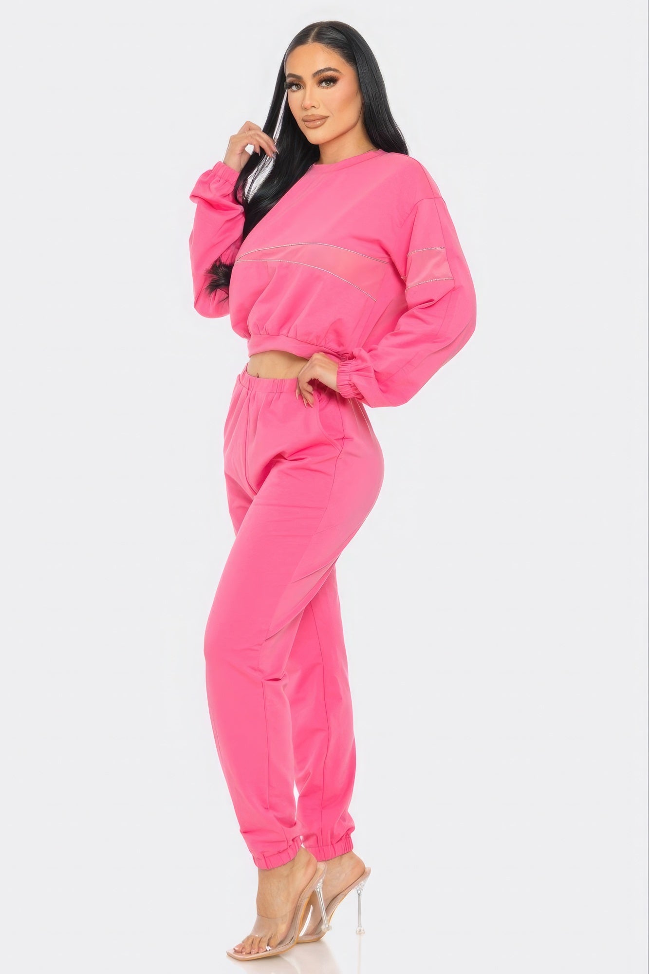Woman wearing a bright pink tracksuit on a white background