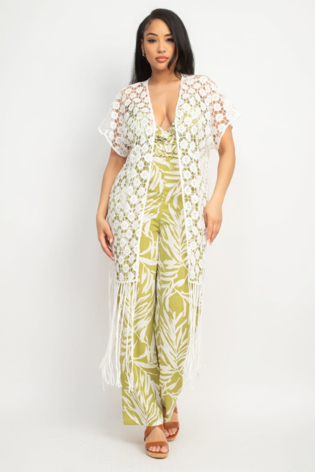 Woman wearing a green and white floral jumpsuit with a matching cover-up on a white background