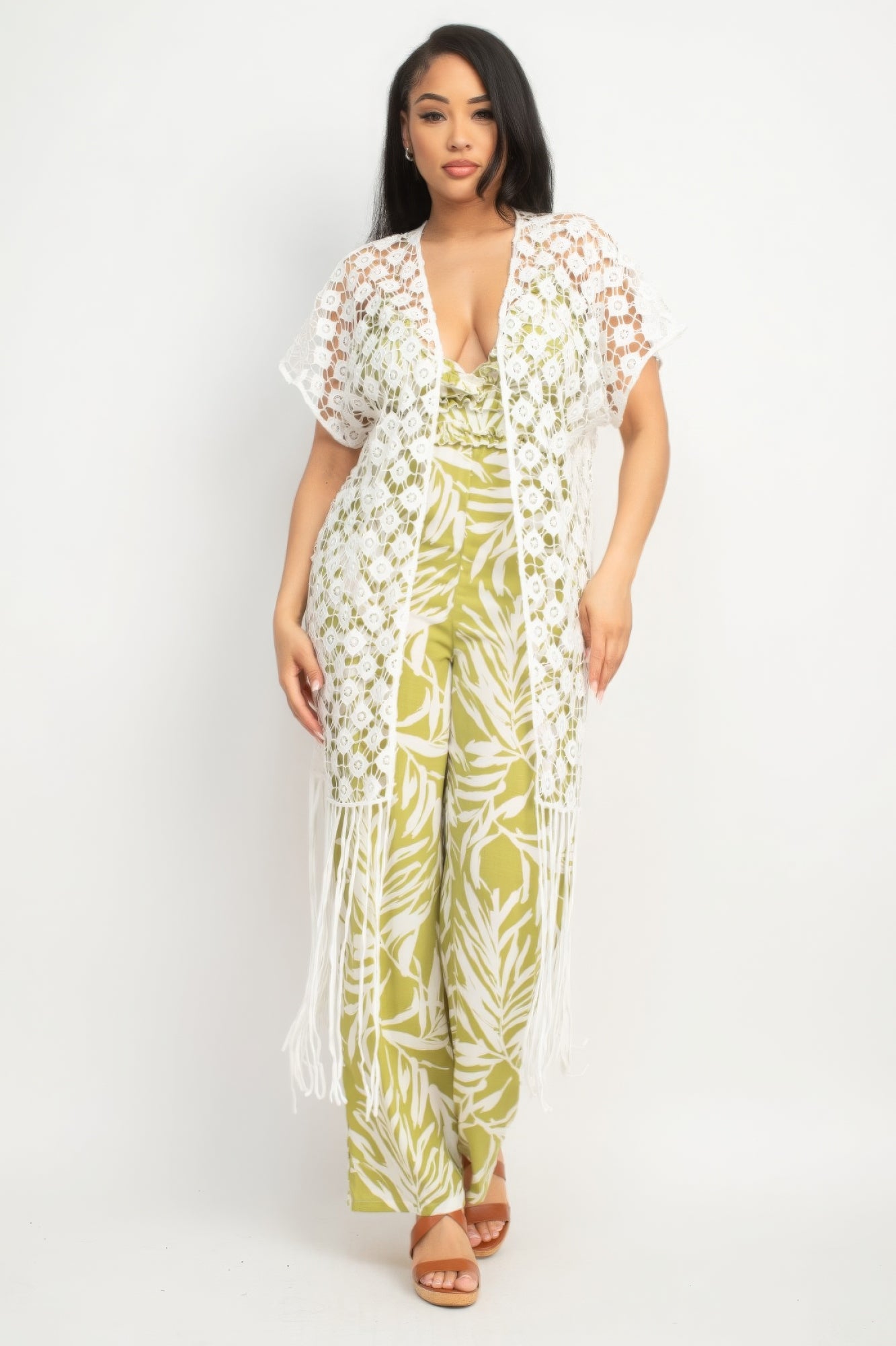 Woman wearing a green and white floral jumpsuit with a matching cover-up on a white background