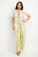 Woman wearing a floral jumpsuit with a matching cover-up on a white background